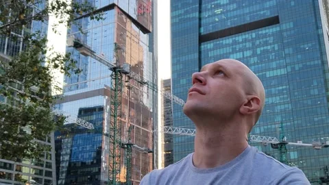 Young man looking at construction of modern skyscrapers Stock Footage 201167319