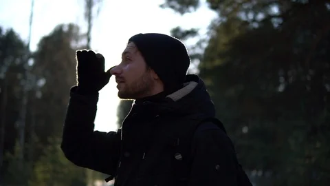 Young man looking into the distance in the winter forest Video stock 93325059