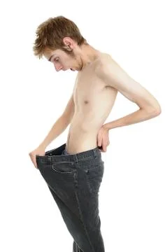 A young man looking down at his old pants when he was fat Stock Photos