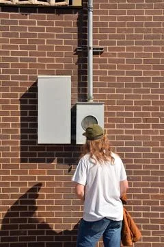 Young Man Looking at Electric Meter 写真素材