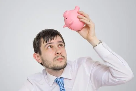 Young man is looking in empty piggy money bank. Foto stock
