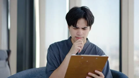 Young man is looking at the files his team submitted, He felt stressed and bored Stock Footage 293473877