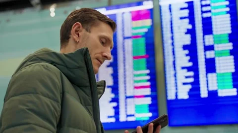 Young man looking at flight schedule at airport. Checking airline departure Stock Footage 170048237