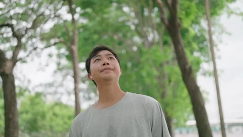 Young man looking forward sadly and listening music with airpods walking  Stock Footage 283187164