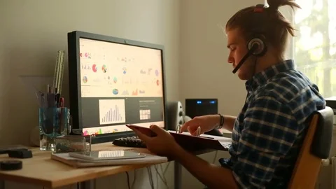 Young man looking on the graphs and doing notes in the notebook 스톡 동영상 75146889
