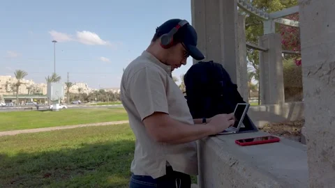 Young man looking at his tablet in a park on a sunny day. Stock Footage 324926725