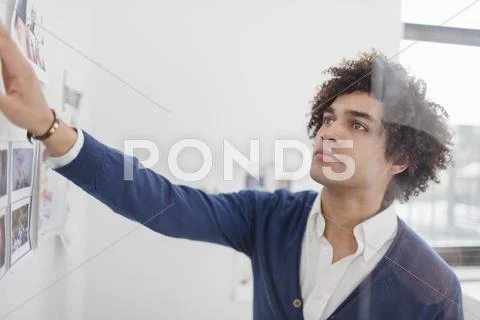 Young man looking at images on wall Stock Photos