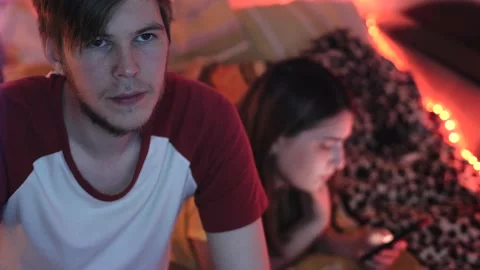 Young man looking at laptop while woman in mobile Stock Footage 130817763