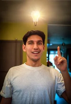 Young man looking at lit up lightbulb. Idea, enlightment concept Stock Photos