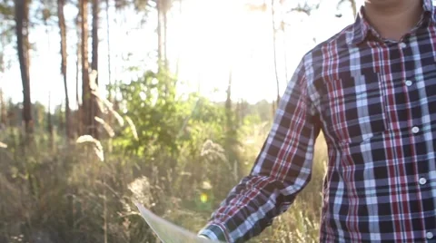  Young man looking a map in a forest at sunset Stock-Footage 69060462