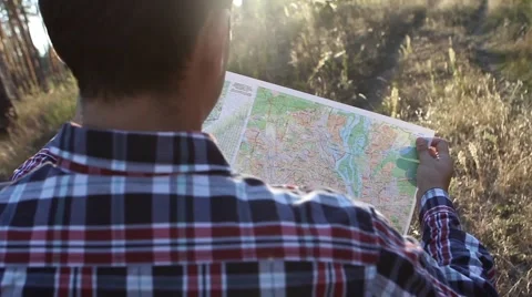  Young man looking a map in a forest at sunset Stock-Footage 69060479