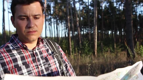  Young man looking a map in a forest at sunset Stock-Footage 69060488