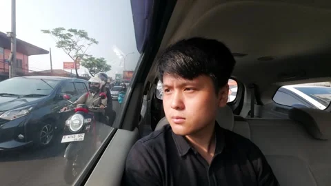 Young Man Looking Out Car Window in Daytime City Traffic on Busy Urban Street Stock Footage 336225272