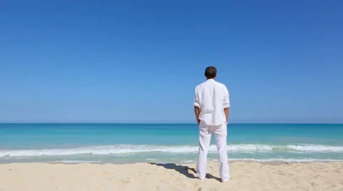 Young man looking out to sea at the beach Vacation travel concept Stock Footage 62908056