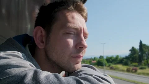 Young man looking out of train window while traveling by railway through Balkans Stock Footage 251004221