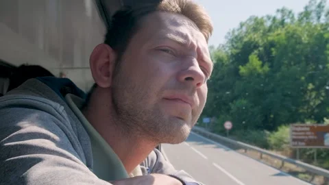 Young man looking out of train window while traveling by railway through Balkans Stock-Footage 256093981