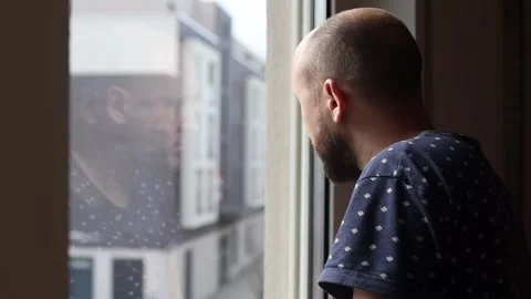 Young man looking out the window Stock Footage 242719875