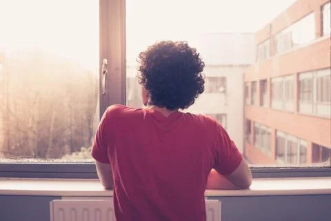 Young man looking out the window Stock Photos