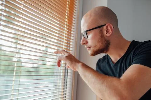 Young man is looking out the window. Stock Photos