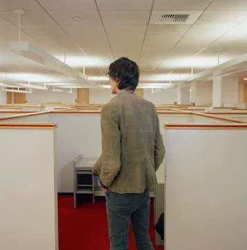 Young man looking over empty office cubicles Stock Photos