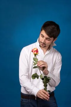 Young man looking to red rose Stock Photos