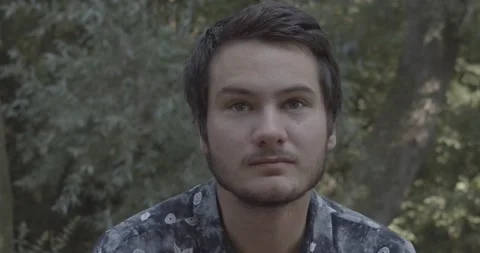 Young man looking to the right and then straight, listening to something Stock Footage 136539322