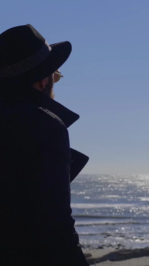Young man looking at sea during winter feeling thoughtful Stock Footage 332418706