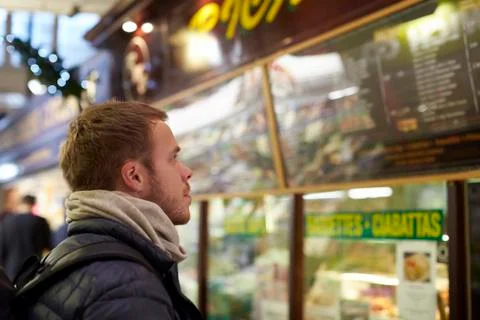Young Man Looking In Shop Window Of Cafe Stock Photos