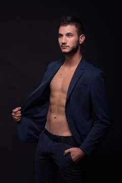 Young man looking sideways, posing shirtless suit jacket pants Stock Photos