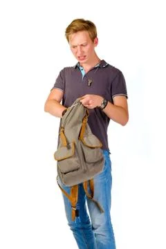 Young man looking for something inside his backpack Stock Photos