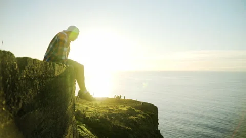 Young man looking at sunset view, ocean and sunlight in the background Stock Footage 146631781
