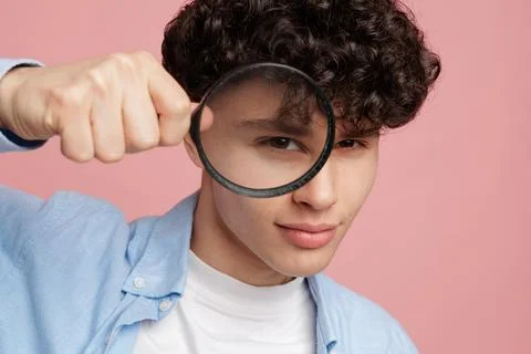 Young man looking through magnifying glass investigation research and audit.. Stock Photos