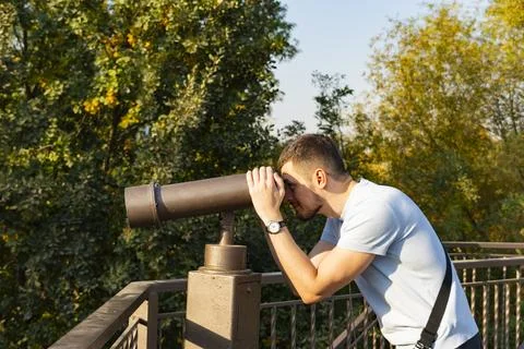 Young Man Looking Through Observation Telescope in Park Stock Photos
