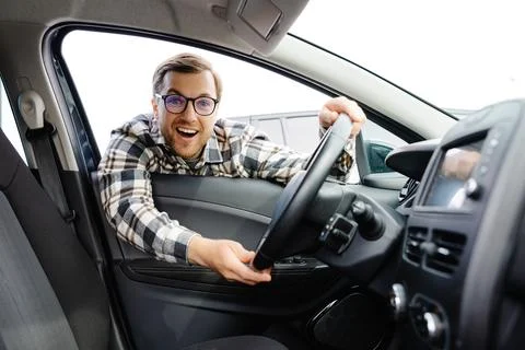 Young man looking through window inside new car, checking it before purchas.. Stock Photos
