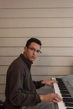 Young man looking up while playing electric piano, copy space Stock Photos