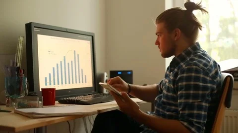 Young man looks absorbed while checking results with one on the smartphone Stock Footage 75150208