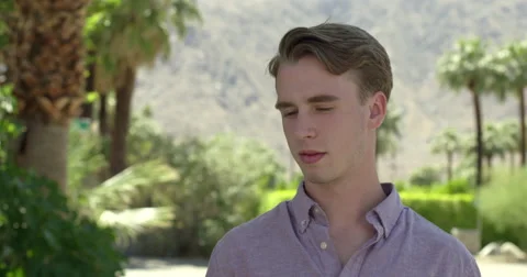 Young man looks around while waiting in desert location 4K Stock Footage 63869875