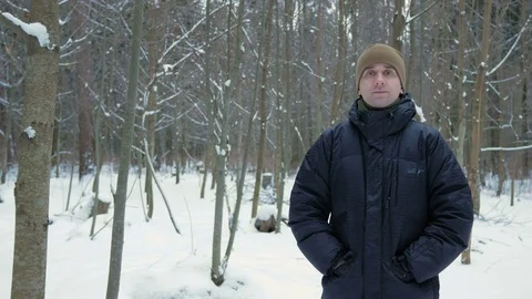 The young man looks into the camera and smiling in winter forest. Snowy Stock Footage 71206092