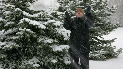 The young man looks into the camera and smiling in winter forest. Big snowfall Stock Footage 71214335