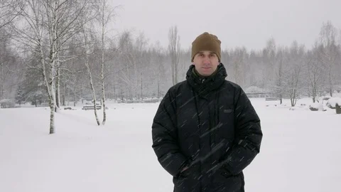 The young man looks into the camera and smiling in winter forest. Big snowfall Stock Footage 71217709