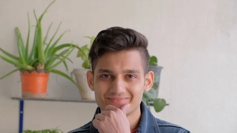 Young man looks at the camera and smiles and laughs with his tooth showing happy Stock Footage 101286793