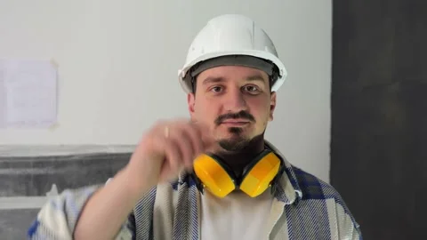 A young man looks into the camera and adjust the white helmet with his hand Stock Footage 236174196