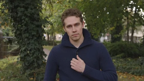 Young man looks at the camera with confidence in a park Vídeo Stock 72680820