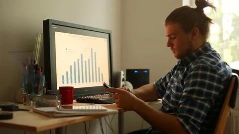 Young man looks irritated while texting messages on smartphone Stock Footage 75150243