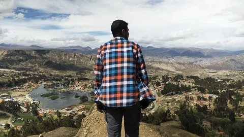 A young man looks at the landscape next El Alto of La Paz Bolivia Stock Footage 125282986