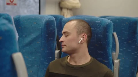 The young man looks out of the train window and smiles dreamily, then returns to Stock Footage 199519942