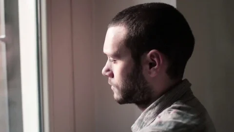 Young Man Looks Outside Window, Thinking Stock Footage 72369504