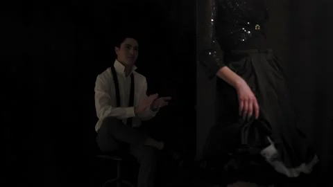 A young man looks passionately at a dancing girl in a dark room. Stock Footage 148503305
