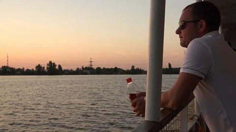 A young man looks at the river from the deck of a motor ship Stock Footage 85367578