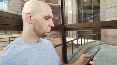 Young man looks at smartphone Stockbeeldmateriaal 201636053